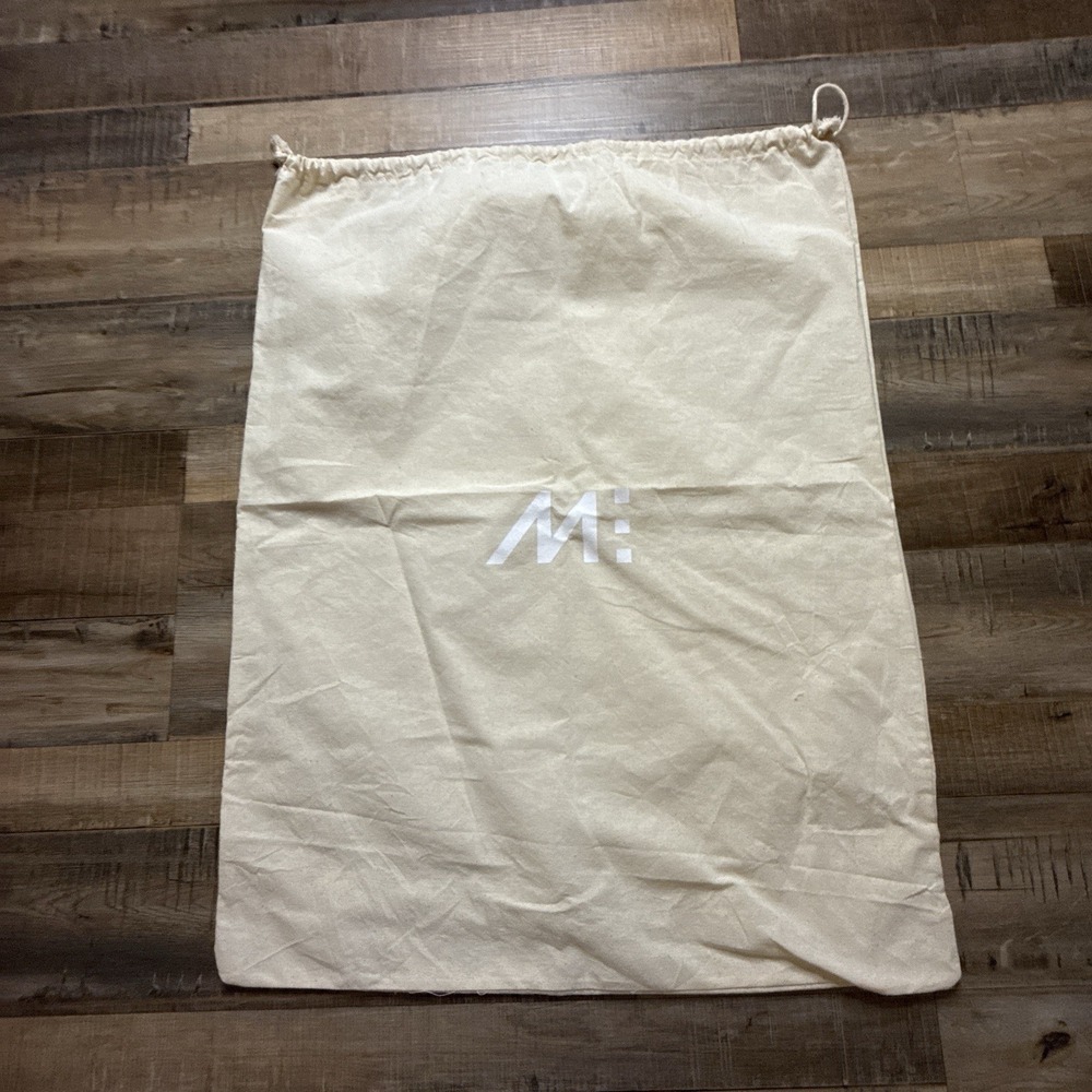 cream-colored fabric drawstring dust bag featuring the Monos brand logo 25 X 19